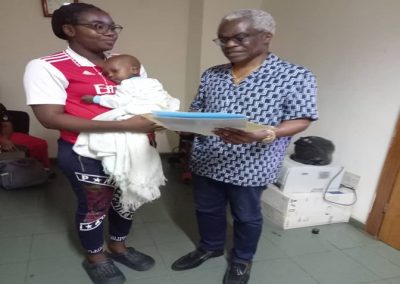 LHCHF CEO/ Founder Dr Benjamin Odeka presenting PTAP Medical Grant to a parent, Mrs Ifeanyi for Baby Desmond to support his medical treatment at National Hospital Abuja – July 2023