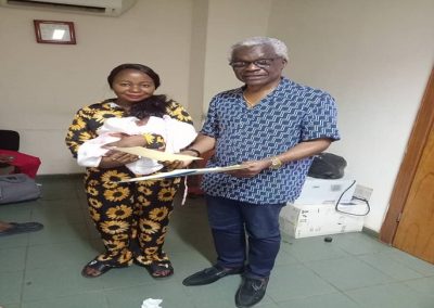 LHCHF CEO/ Founder Dr Benjamin Odeka presenting PTAP Medical Grant to a parent, Mrs Ebenezar for Baby Ebenezer to support his medical treatment at National Hospital Abuja – July 2023