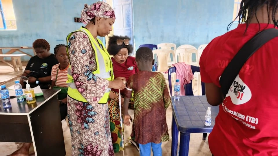 TB testing officer measuring a child's arm circumference
